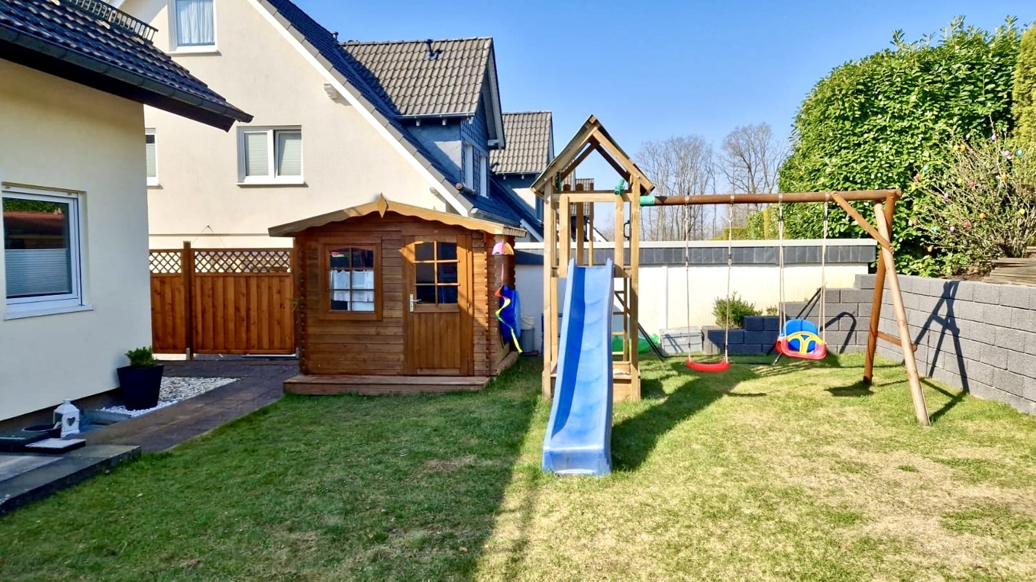 Gartenhaus und Massivholz-Spielturm mit Schaukeln und Rutsche