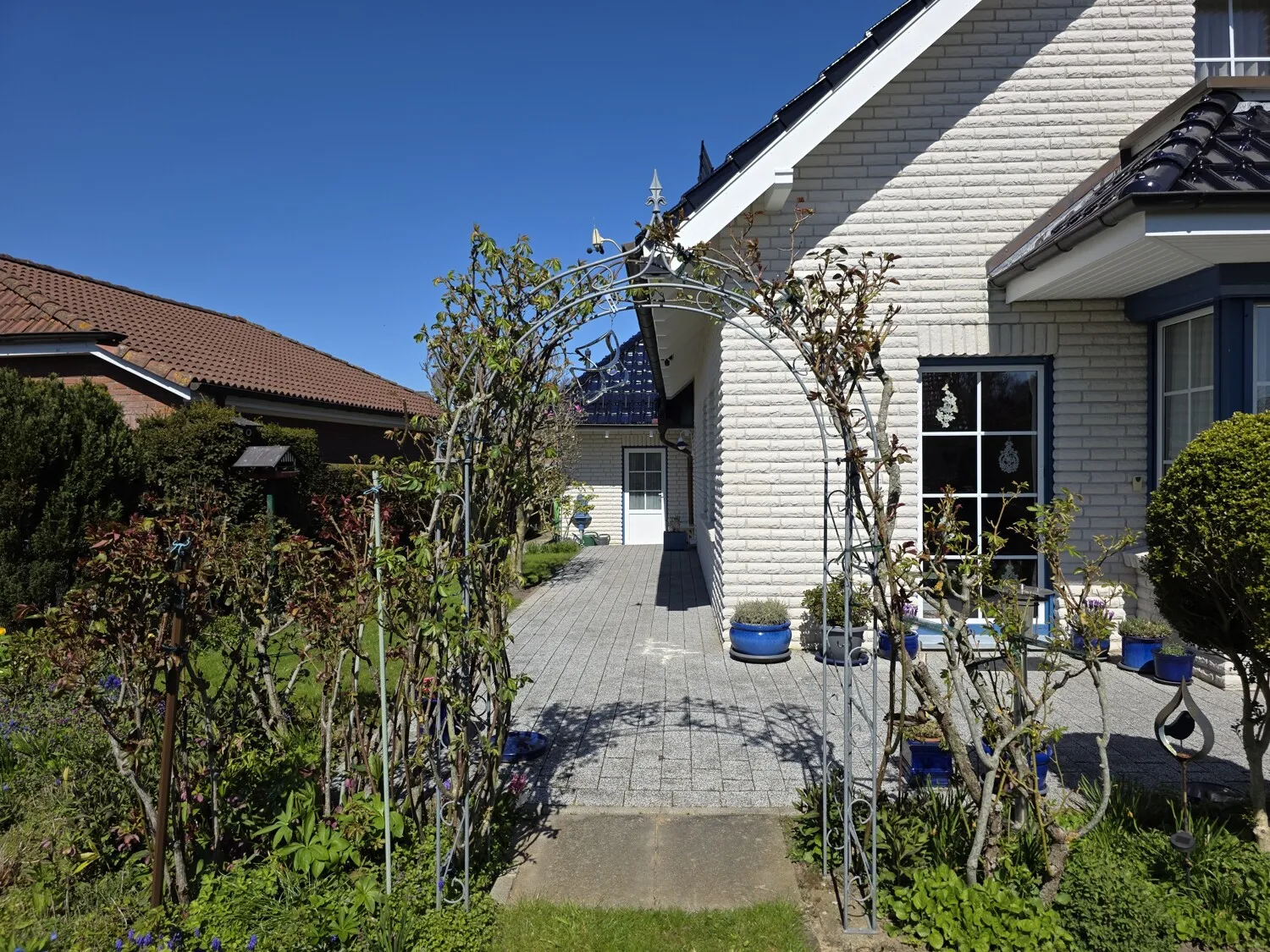 Liebevoll angelegter Garten mit charmantem Rosenbogen