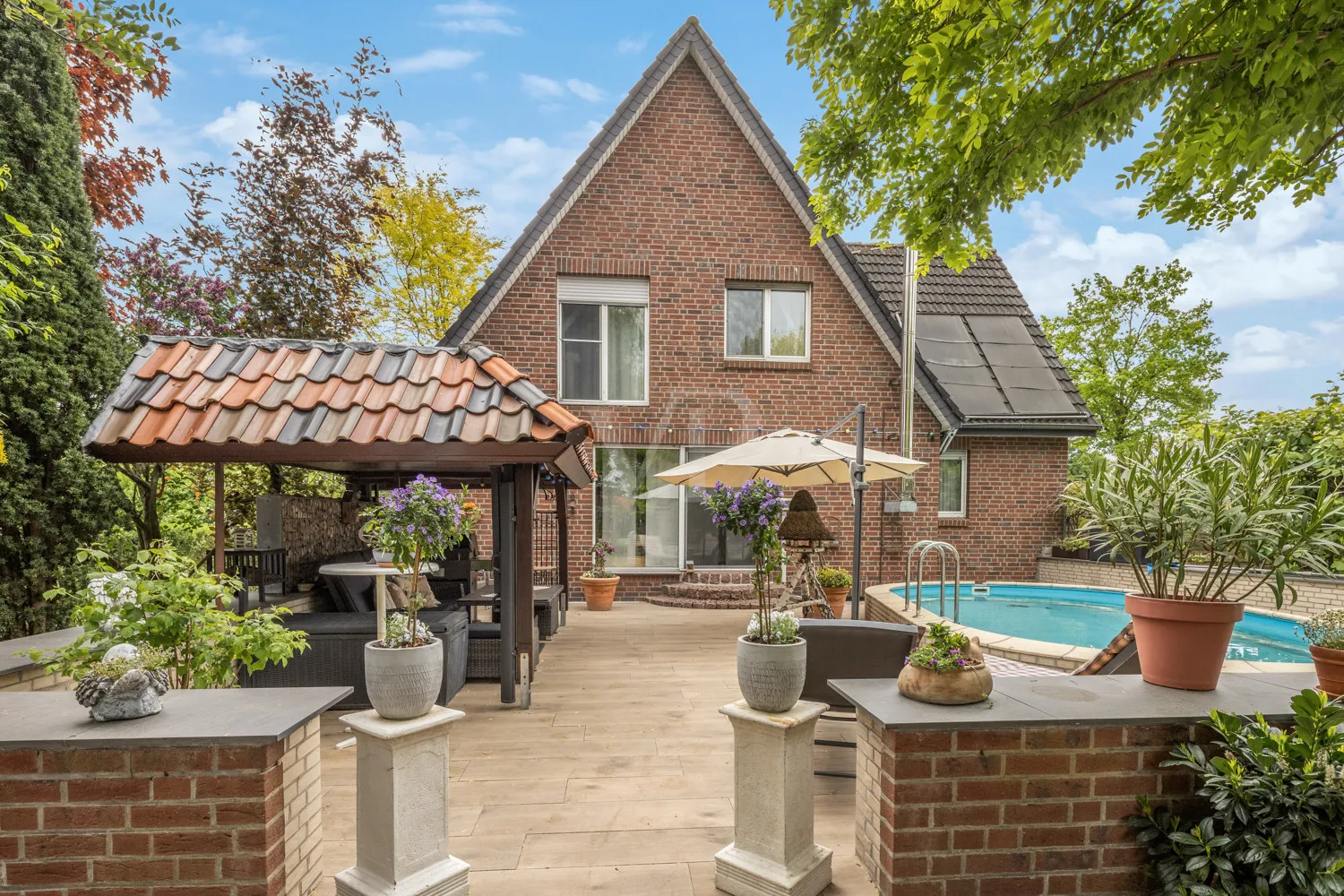 Rückansicht mit Terrasse und Poolanlage