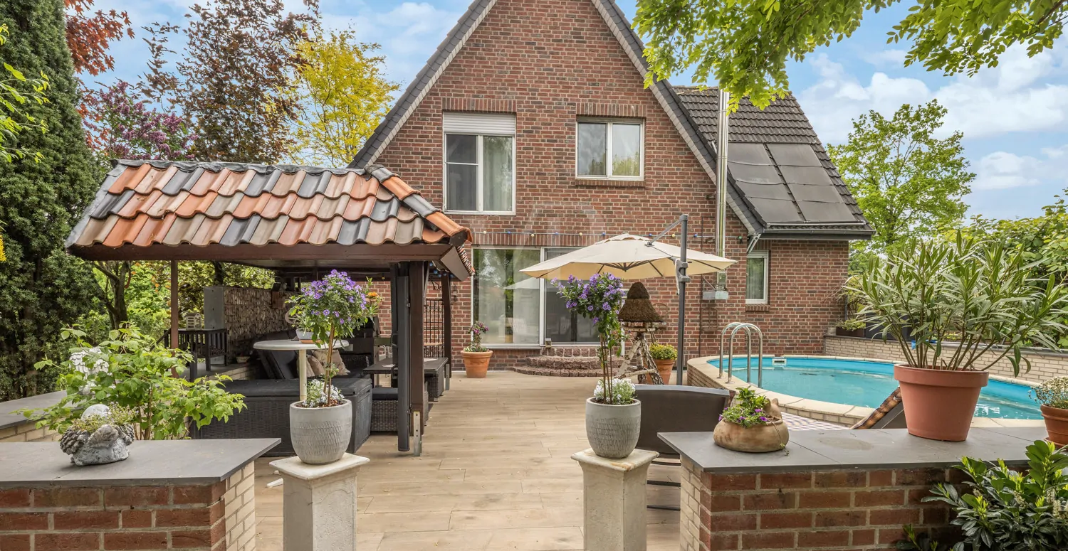 Rückansicht mit Terrasse und Poolanlage