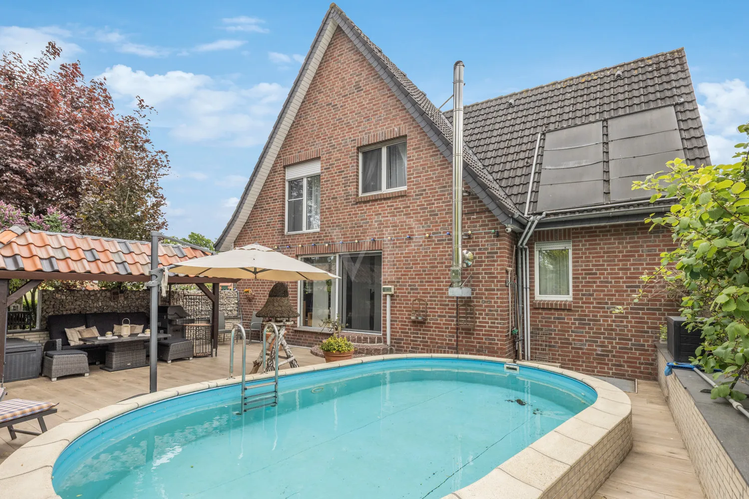 Rückansicht mit Terrasse und Poolanlage