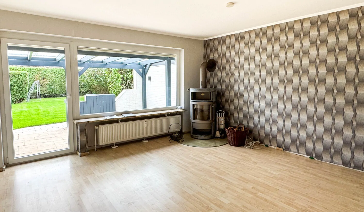 Wohnzimmer mit Kaminofen und Zugang zur überdachten Terrasse im Erdgeschoss