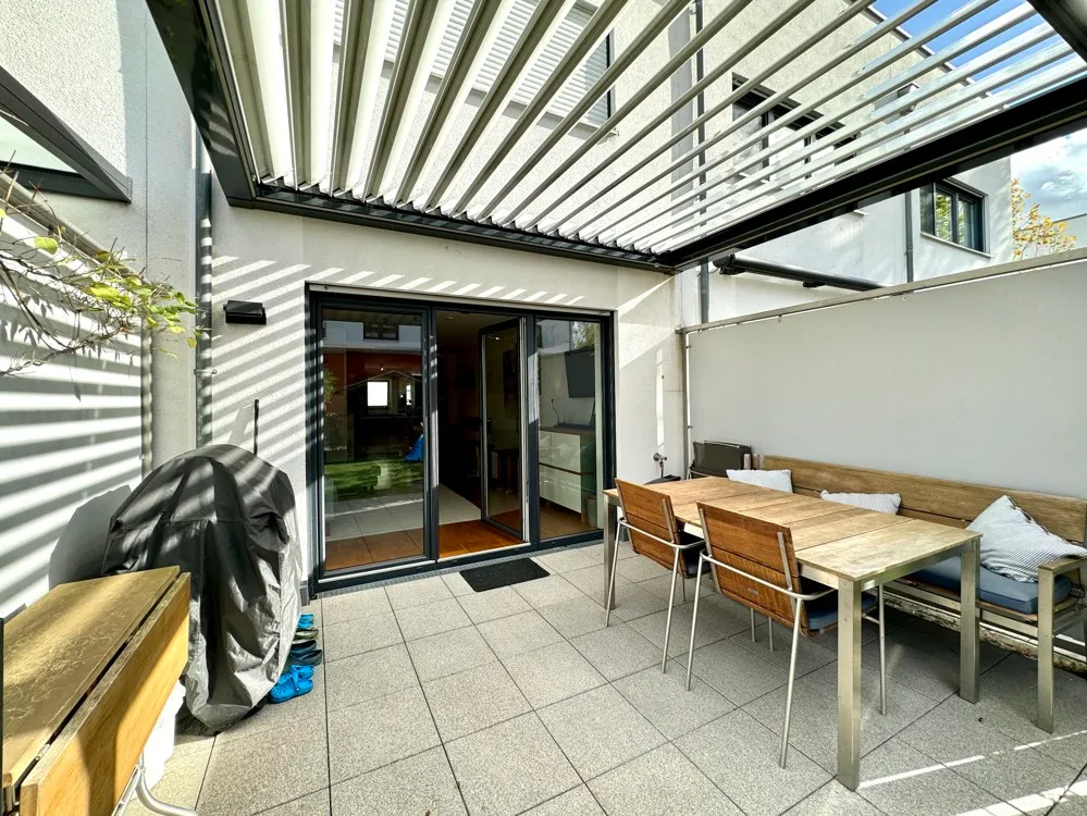 sonnige Terrasse mit Lamellen-Terrassenüberdachung
