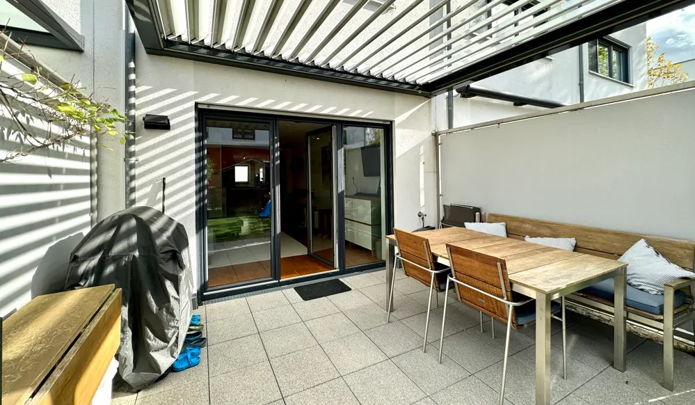 sonnige Terrasse mit Lamellen-Terrassenüberdachung