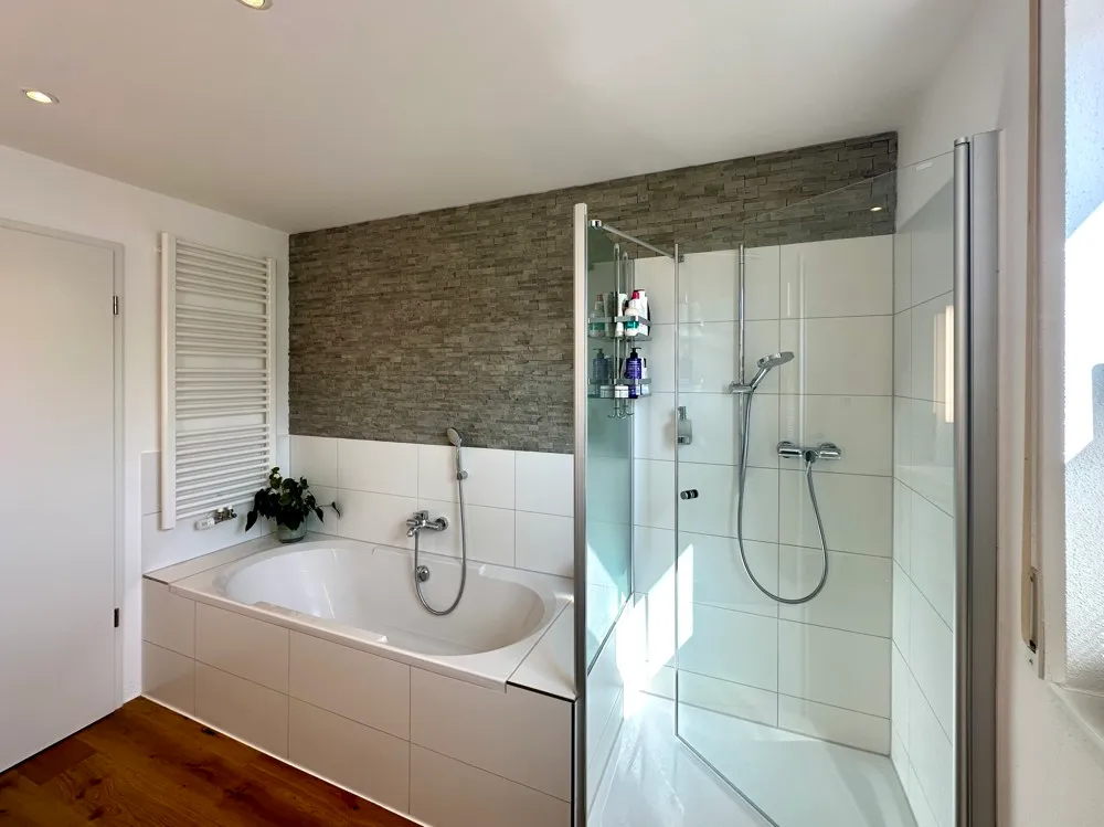 Badezimmer mit Badewanne und Glasdusche