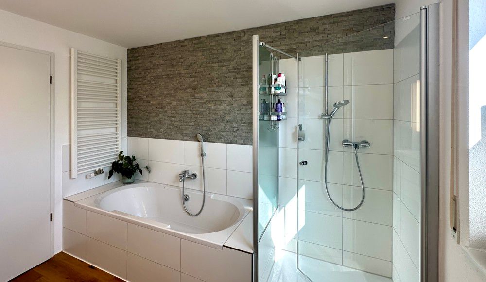 Badezimmer mit Badewanne und Glasdusche