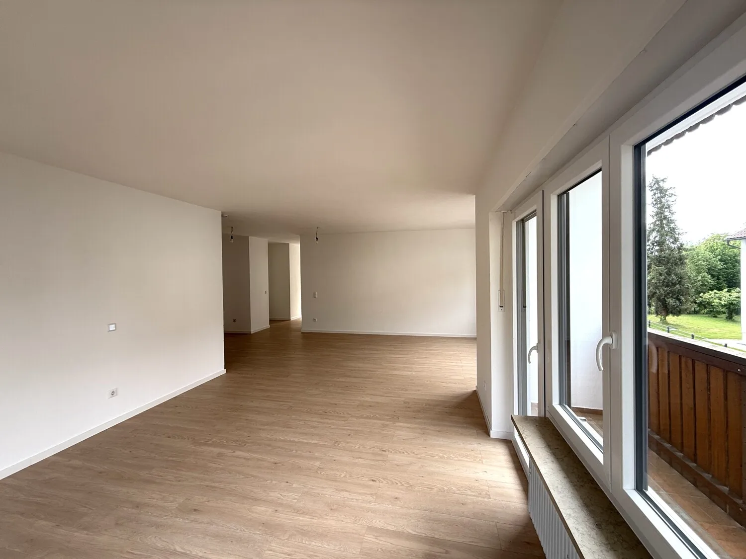 Wohnbereich mit großen Fensterflächen und Balkonzugang