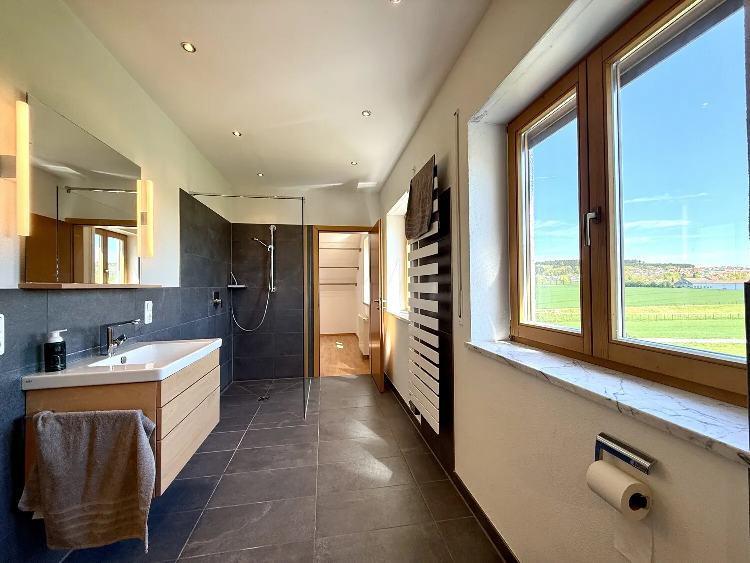 Großzügiges Badezimmer mit Glasdusche und Weitblick