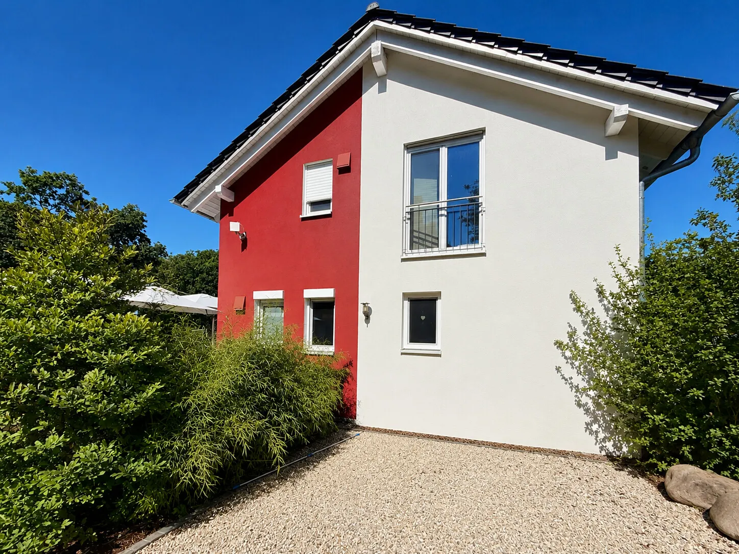 Sonnige Außenansicht mit klarer Architektur und viel Privatsphäre