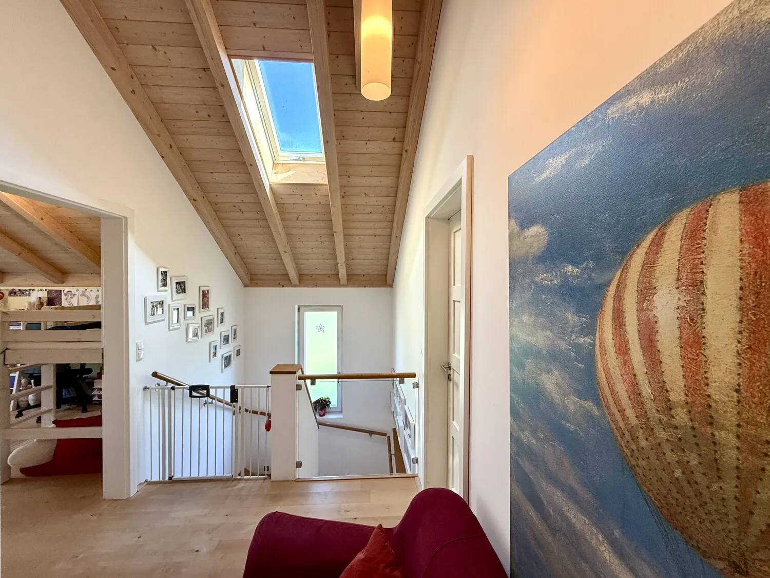 Offene Galerie im Obergeschoss mit Tageslicht und Naturholzdecke