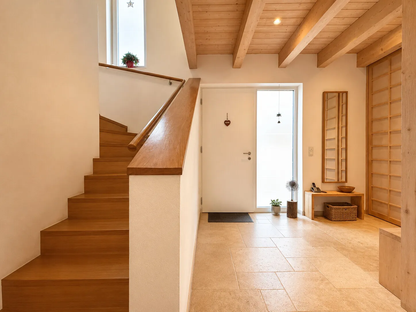 Heller Eingangsbereich mit Natursteinboden und großzügiger Garderobe