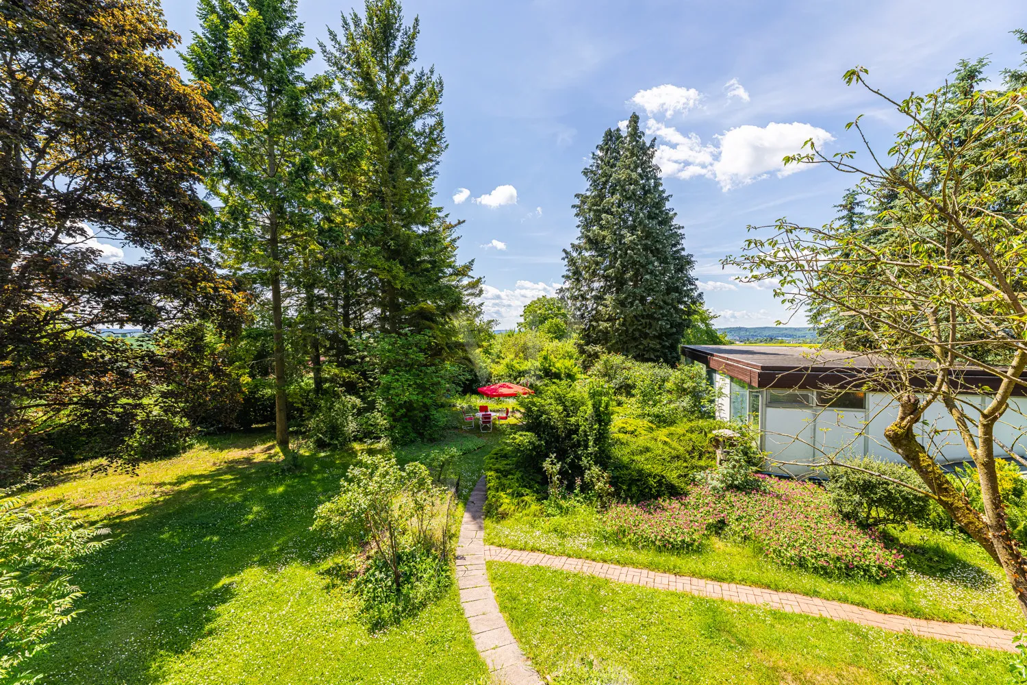 Sicht von der Terrasse OG auf Poolhaus und Garten