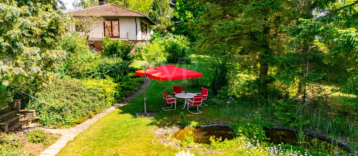 Blick vom Gartenteich mit Freisitz auf die Villa