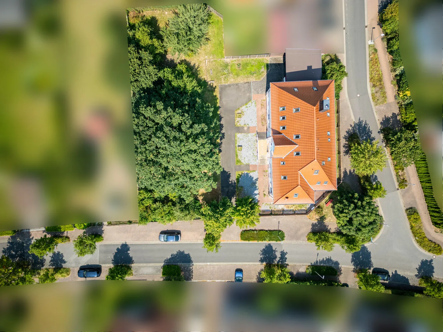 Aufsicht auf Baugrundstück und Mehrfamilienhaus