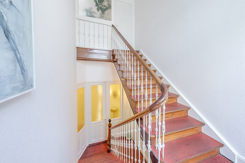 Im Treppenhaus führt eine Holztreppe mit verziertem Geländer in das 1.Obergeschoss (Endetage)