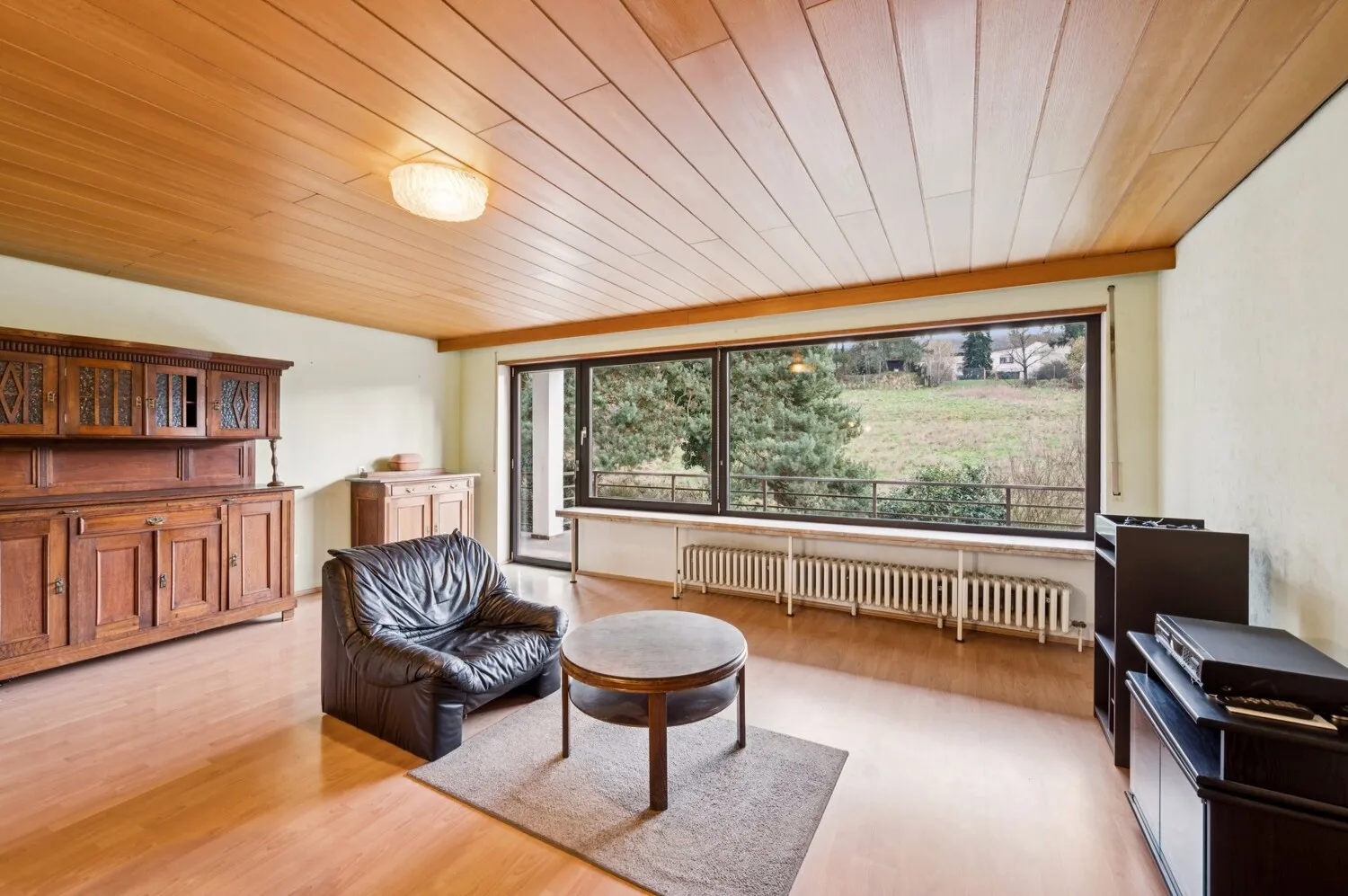 Wohnraum mit Balkonzugang und Blick ins Grüne