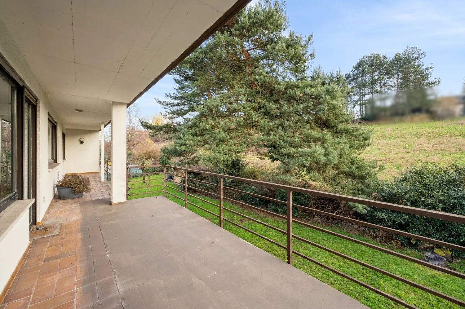 Weitläufiger, überdachter Balkon mit Blick ins Grüne