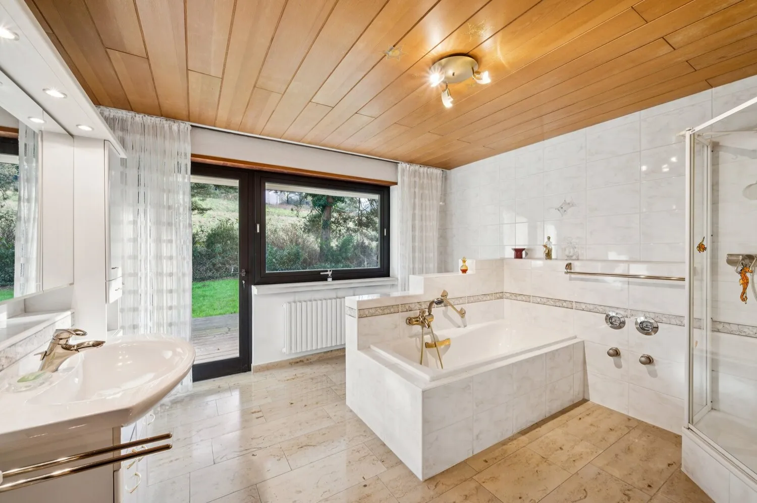 Modernisiertes Tageslichtbad mit Badewanne, Dusche und direkten Terrassen-Zugang