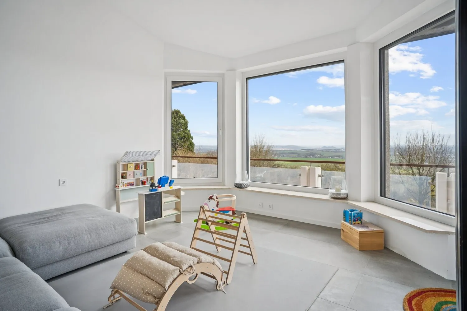 Seitlich angrenzender Raum mit bodentiefen Fenstern und atemberaubender Panoramakulisse