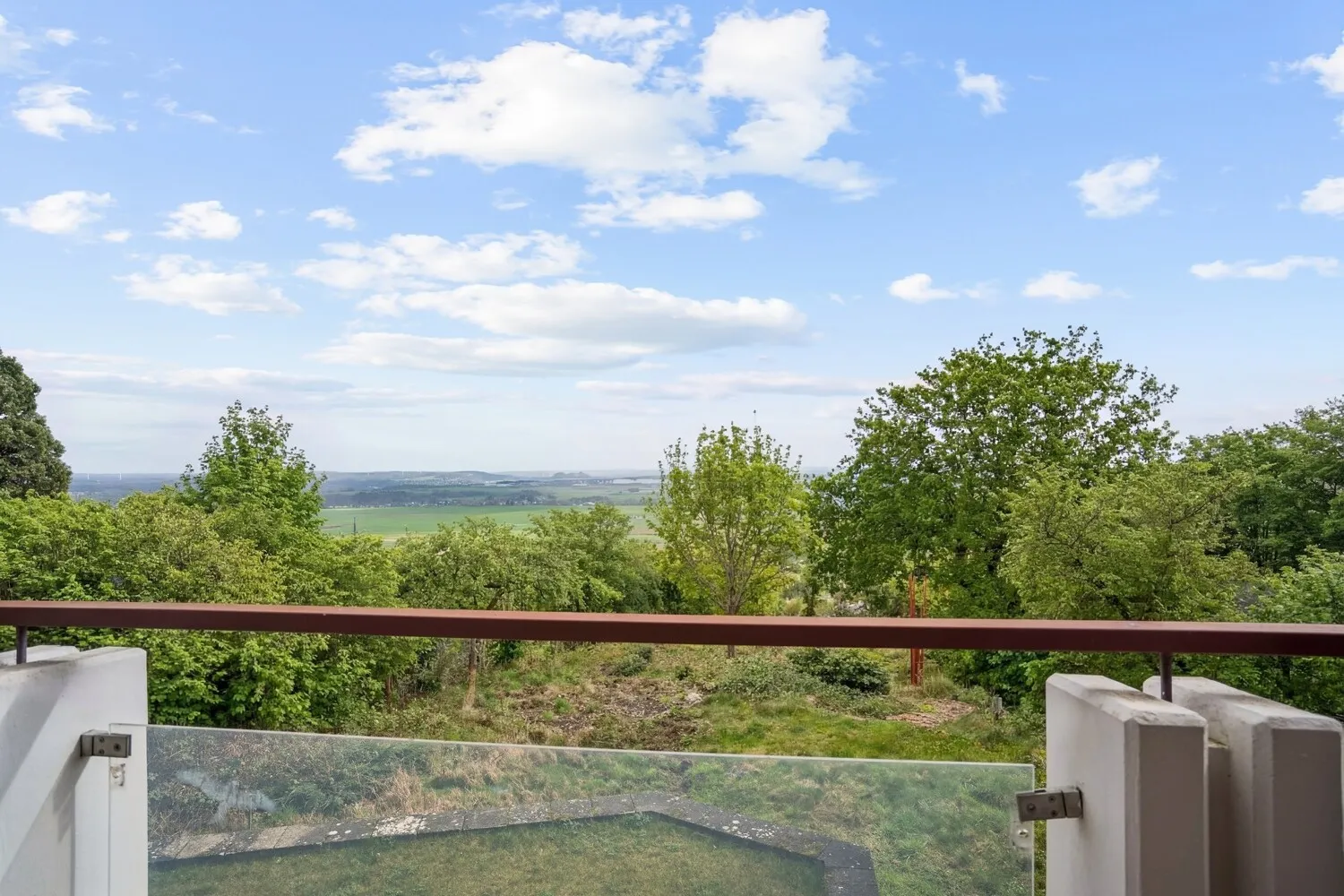 Überdachter Balkon mit spektakulärem Panoramablick über Garten und Landschaft