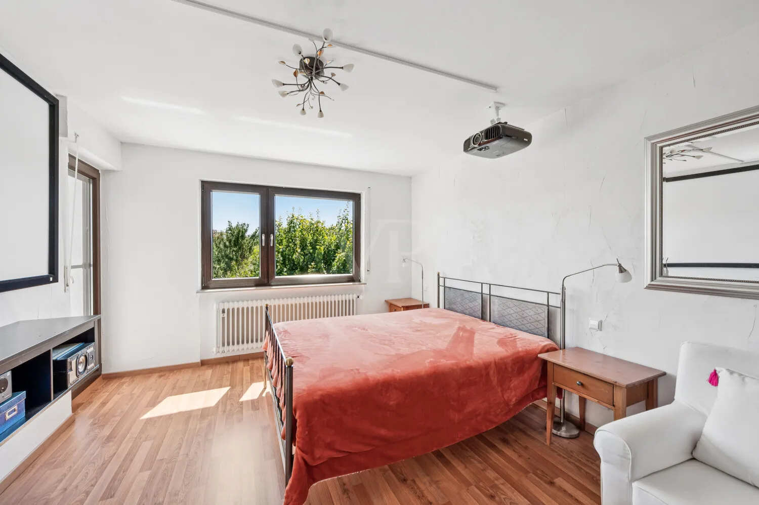 Schlafzimmer mit Zugang zum Balkon im Obergeschoss