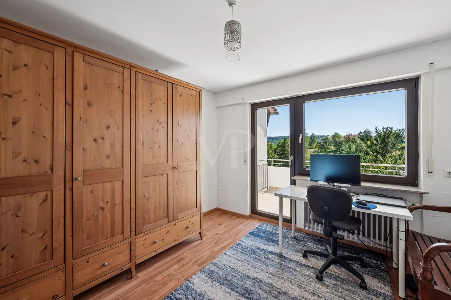Zimmer mit Zugang zum Balkon im Obergeschoss