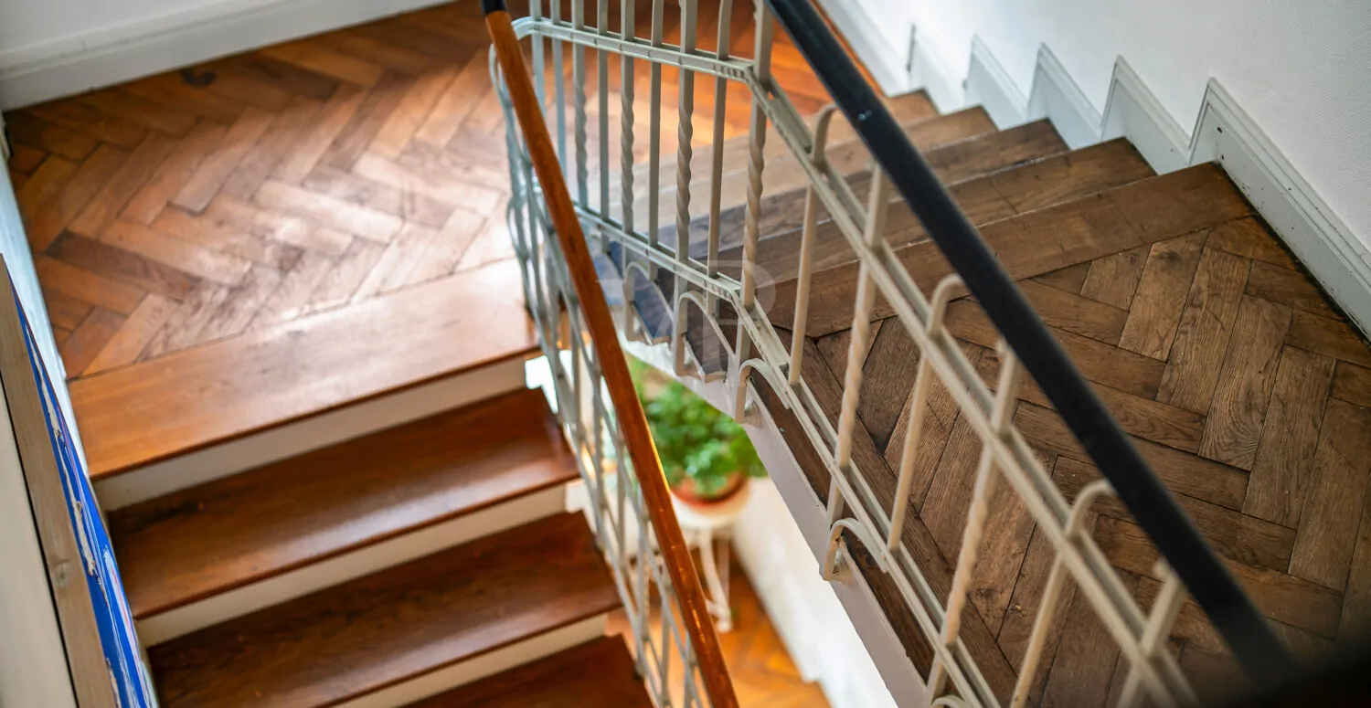 Der elegante Treppengang mit Fischgrätparkett verbindet die Etagen auf geschmackvolle Weise