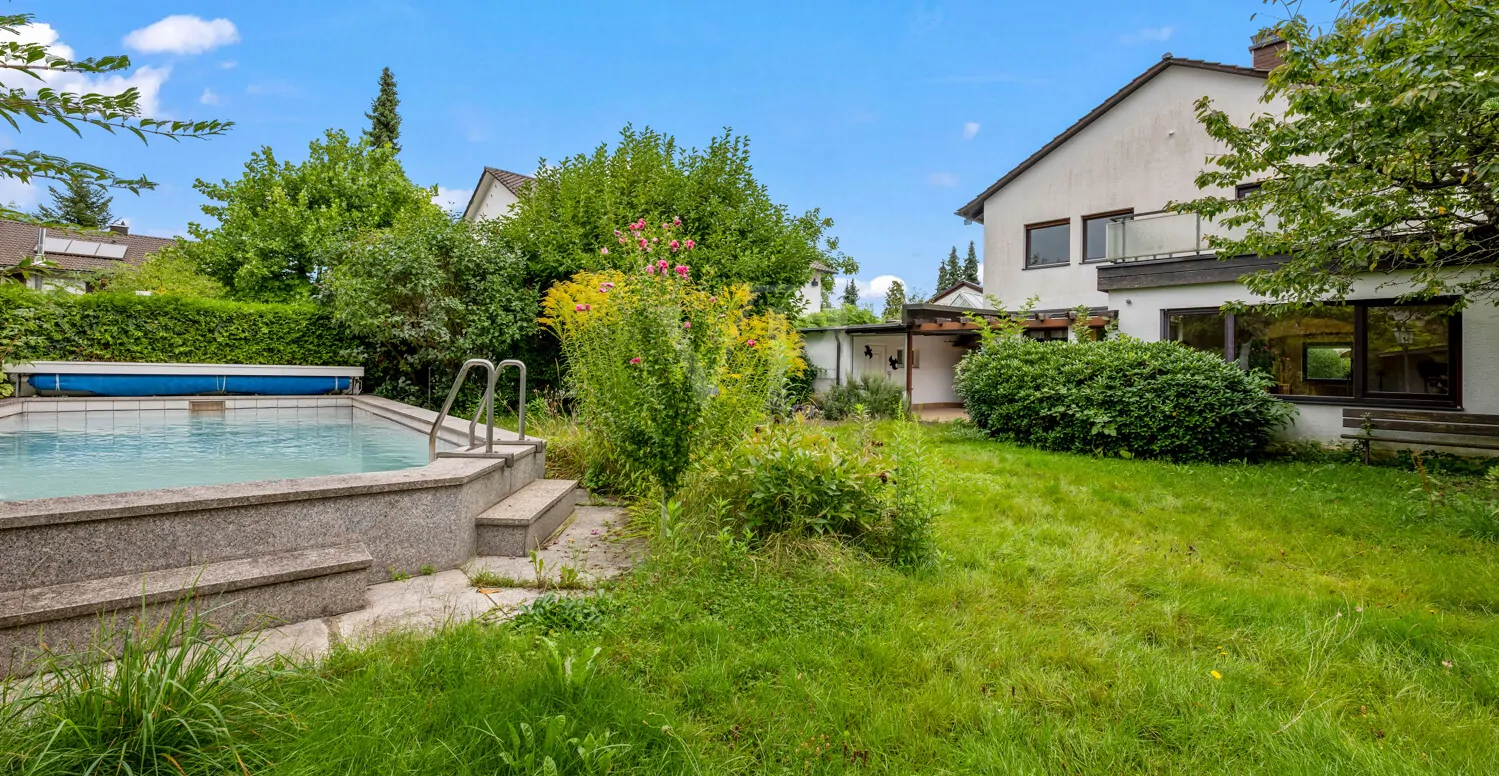 Ansicht vom Garten mit Pool auf das Haus von hinten