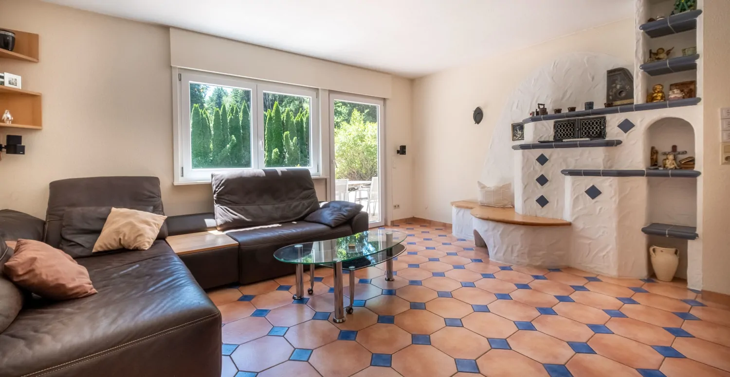 Wohnzimmer mit Kachelofen und Zugang zur Terrasse