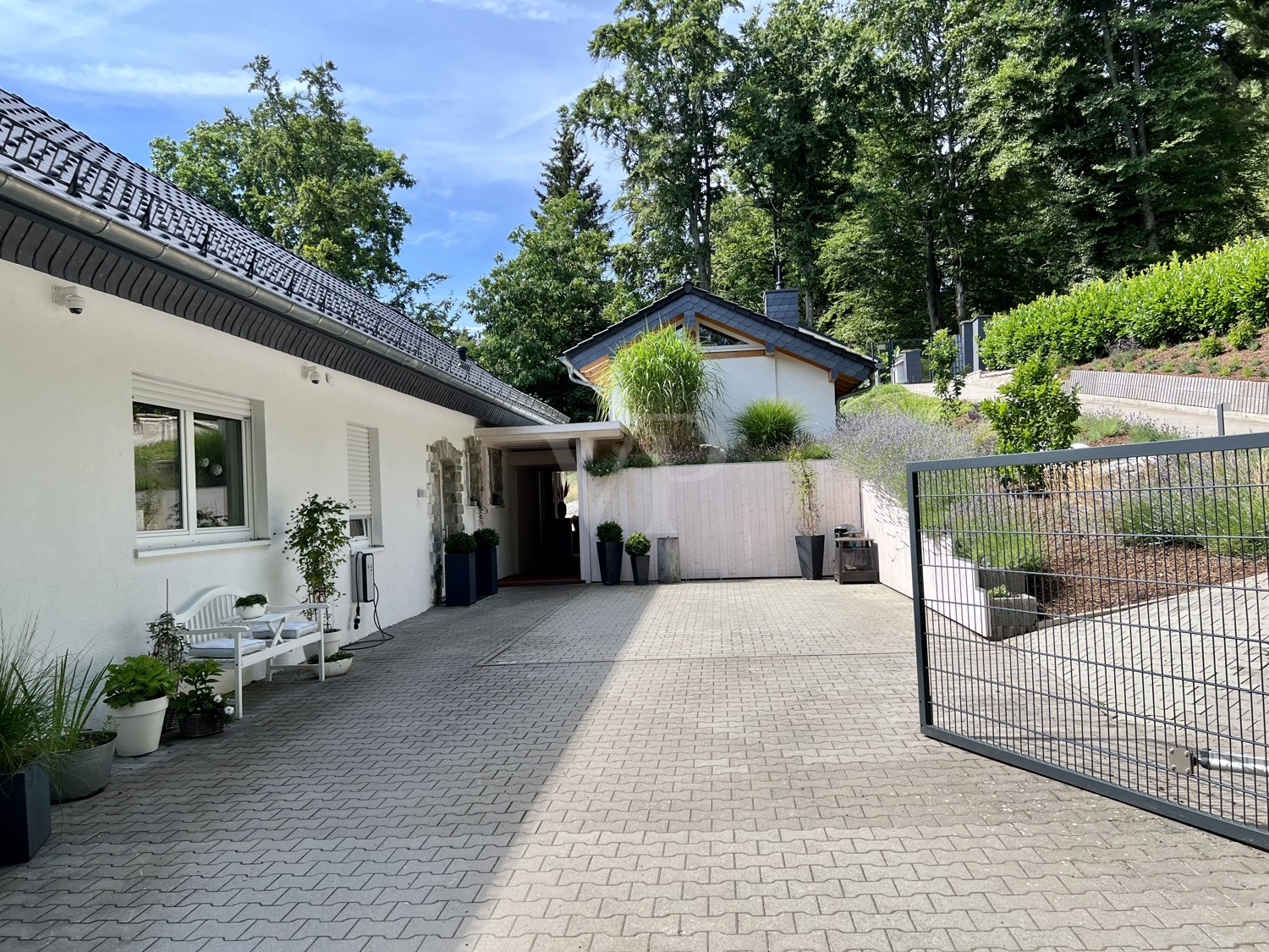 Hofeinfahrt mit Blick auf Haus und Bürohaus