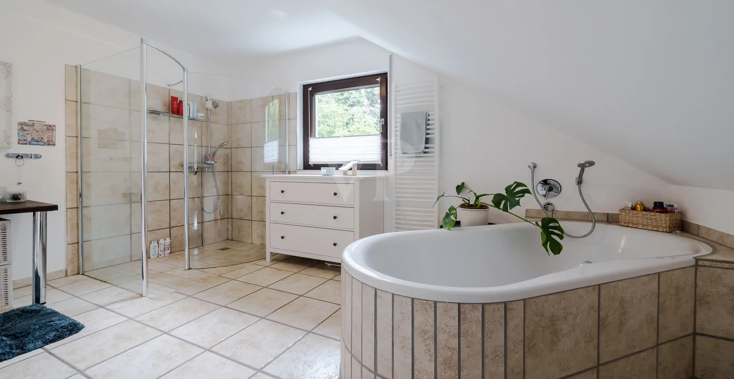 Stilvolles Badezimmer mit freistehender Wanne und großer Dusche