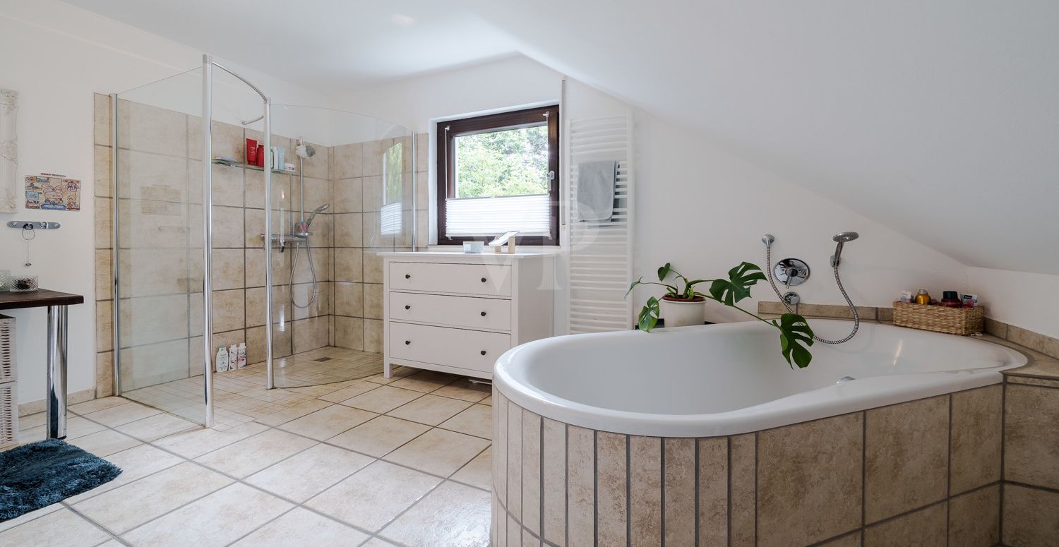 Stilvolles Badezimmer mit freistehender Wanne und großer Dusche