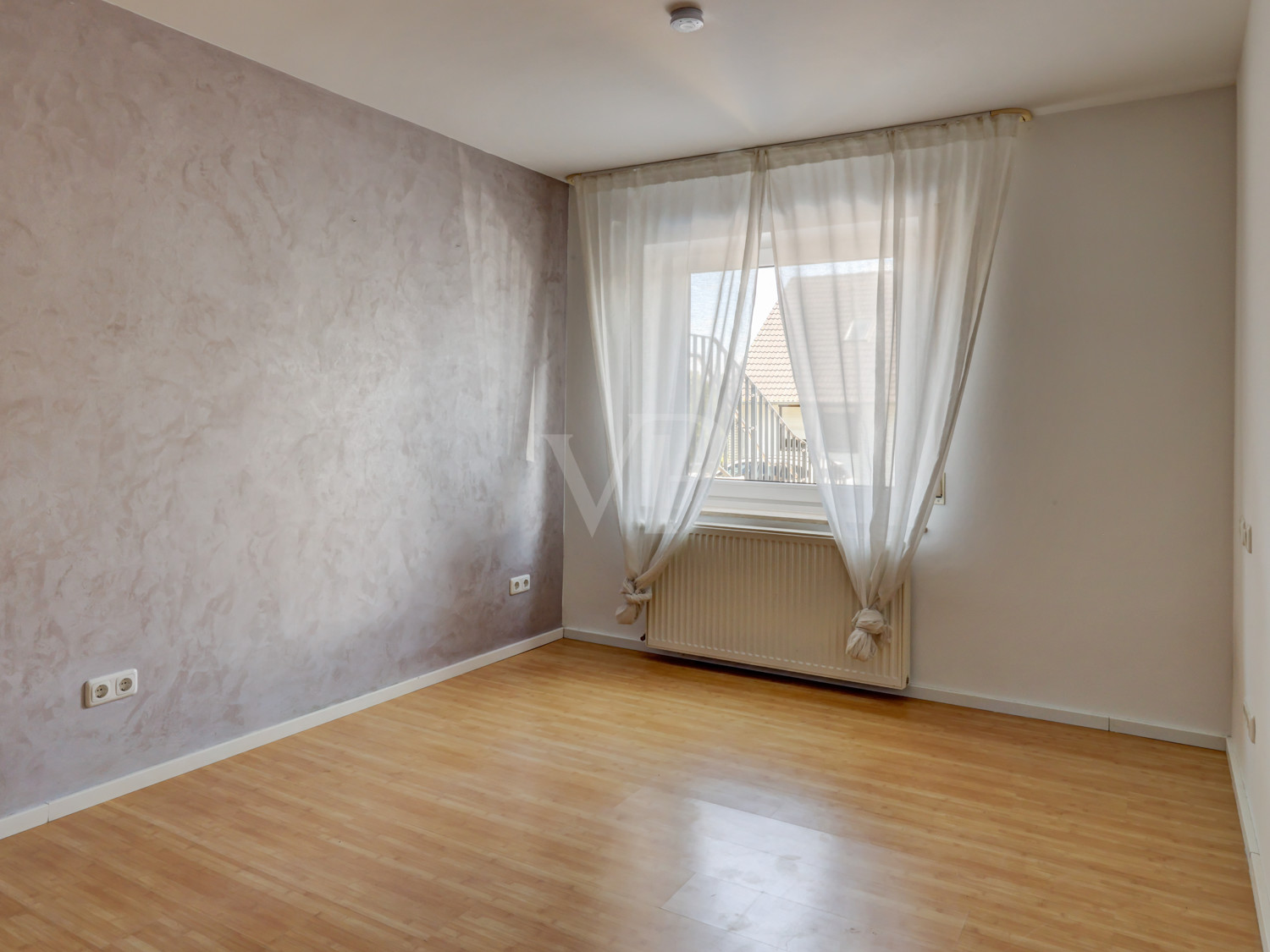 Zimmer im Untergeschoss mit Wand in Spachteltechnik