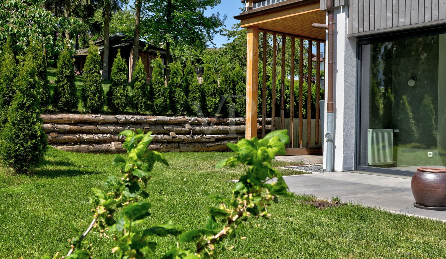 Sonnenterrasse mit Garten und überdachter Terrassenbereich