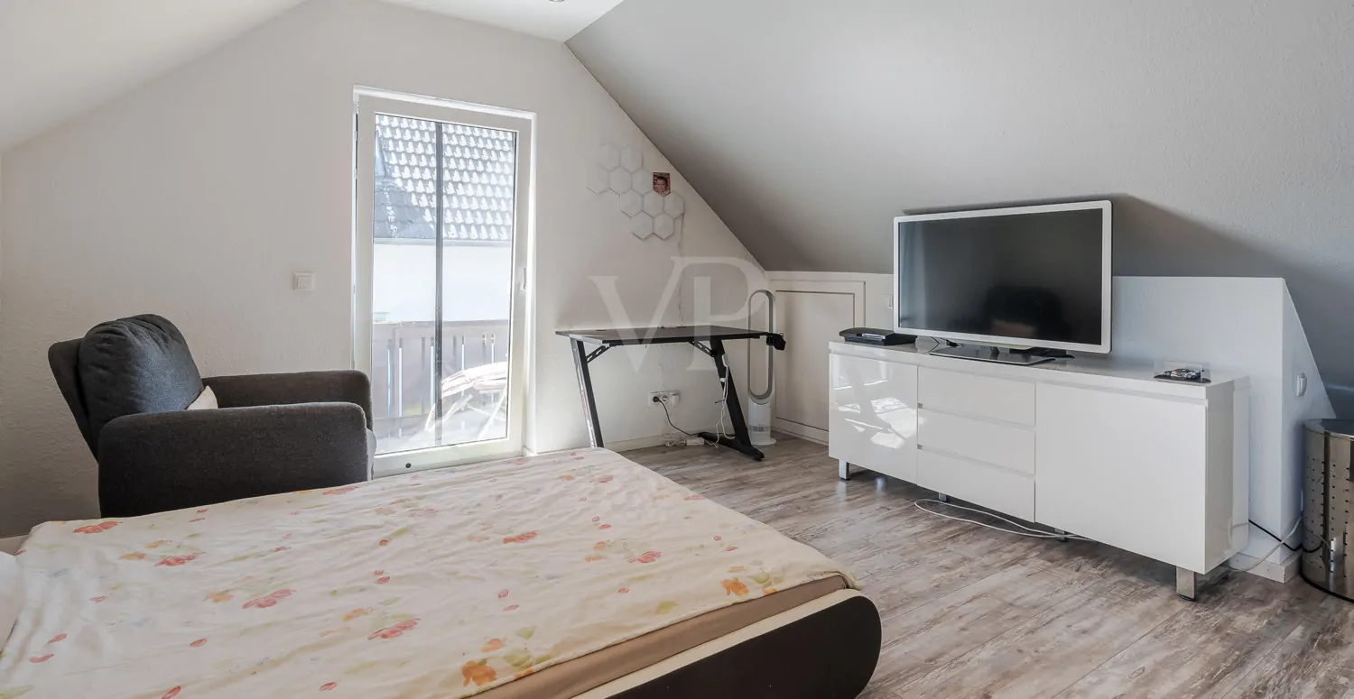 Schlafzimmer mit Balkonzugang im Dachgeschoss