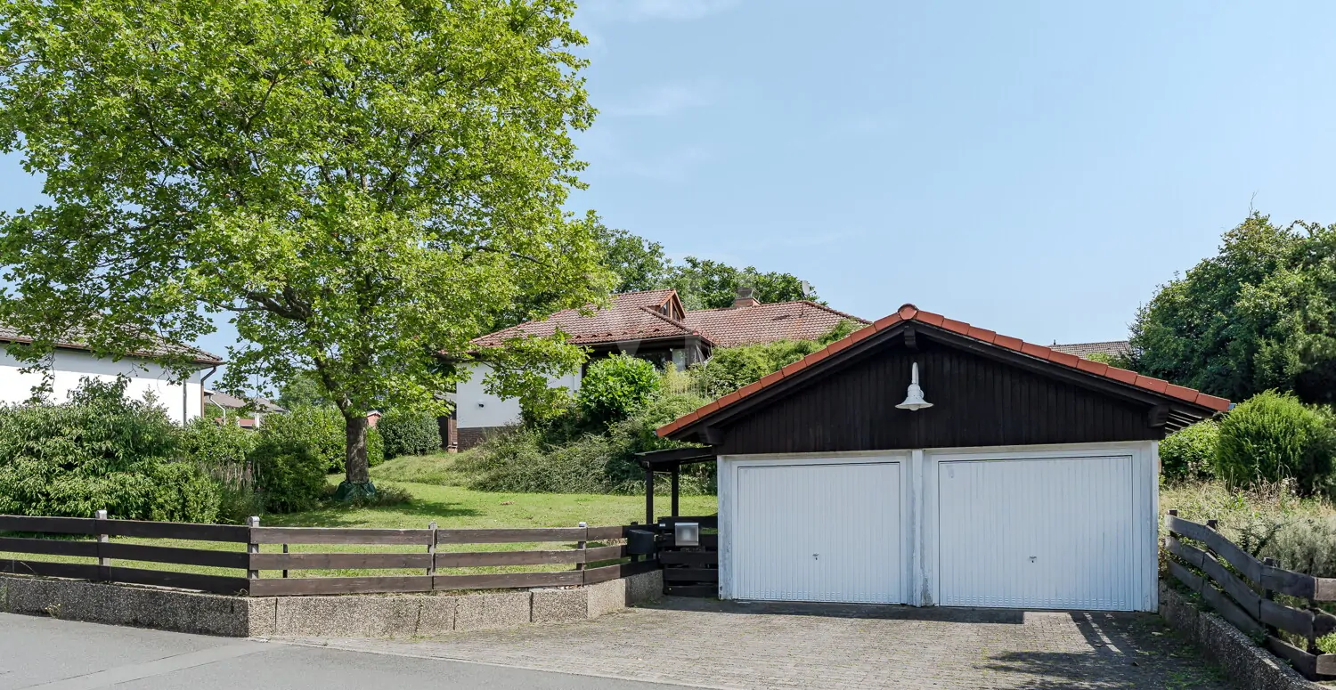 Straßenansicht mit Doppelgarage und Stellplätzen