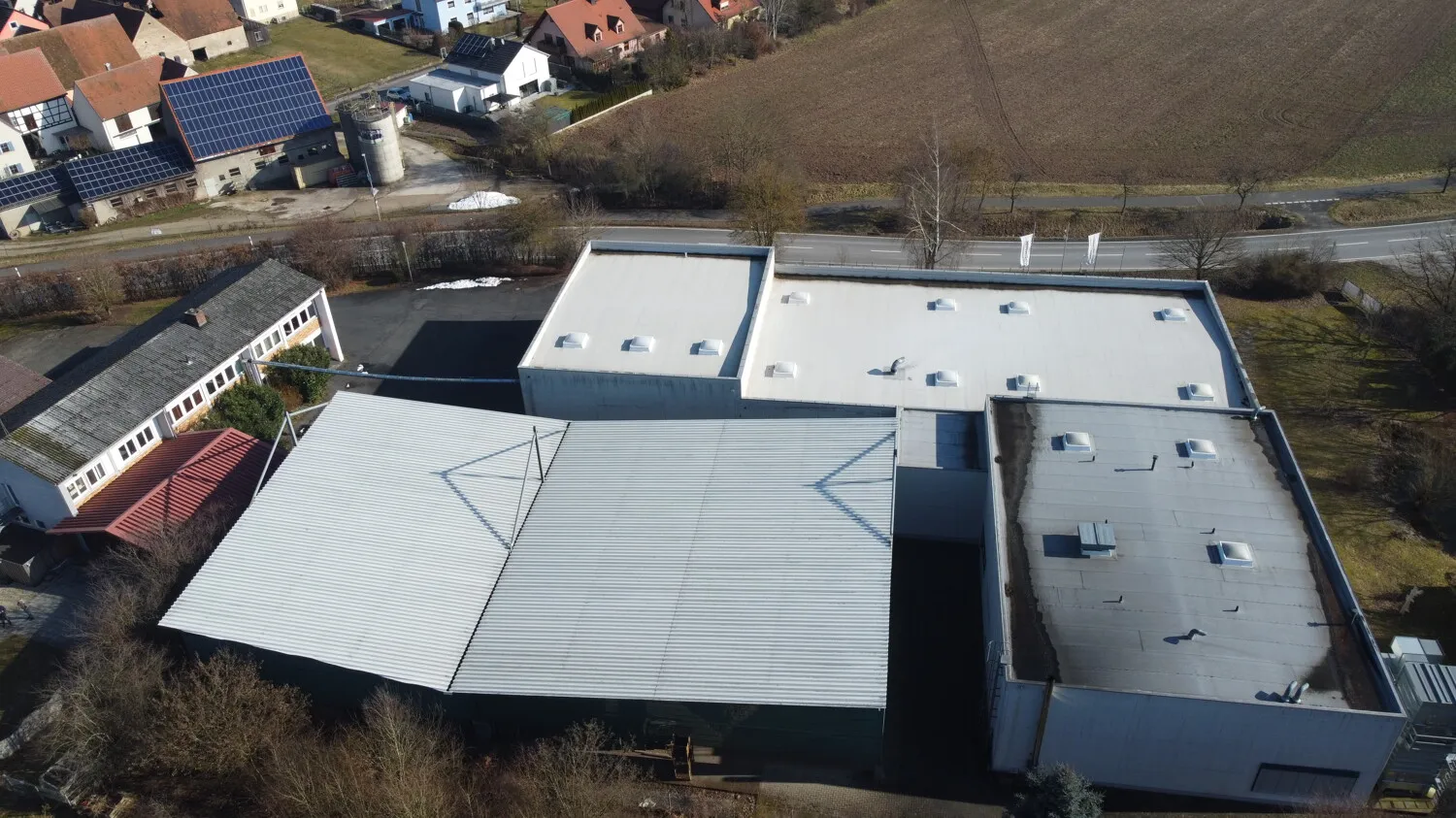 Bürogebäude mit freistehender Industriehalle und offene Lager- und Ladeüberdachung