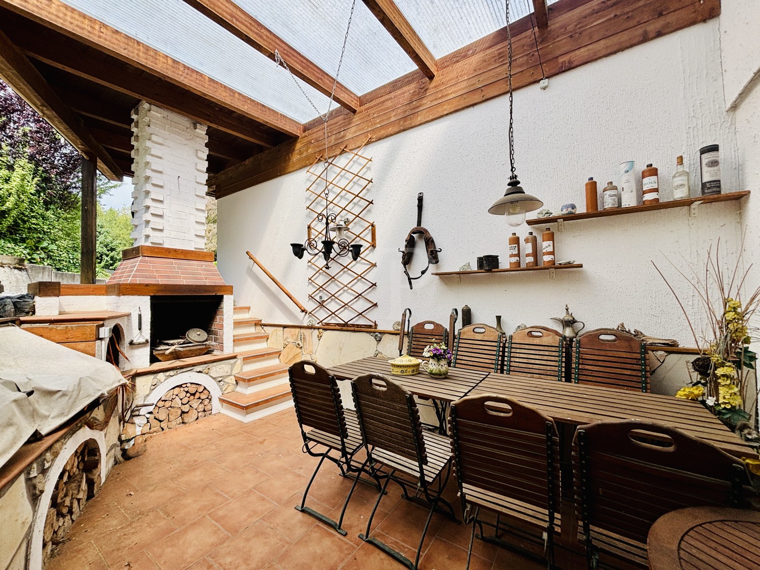 überdachte Terrasse mit Grill und Kamin