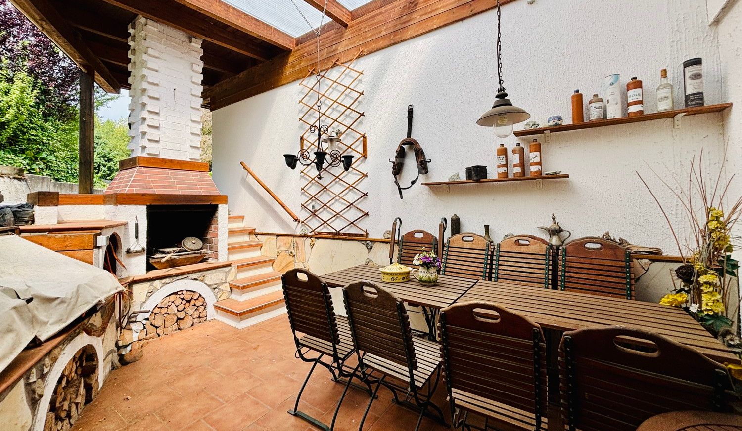 überdachte Terrasse mit Grill und Kamin