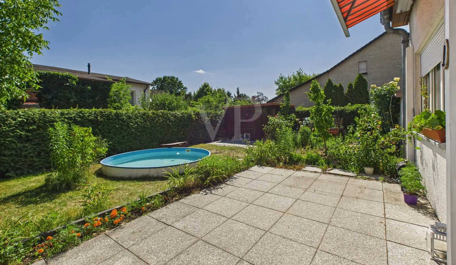 Blick über die Terrasse mit Markise in den Garten