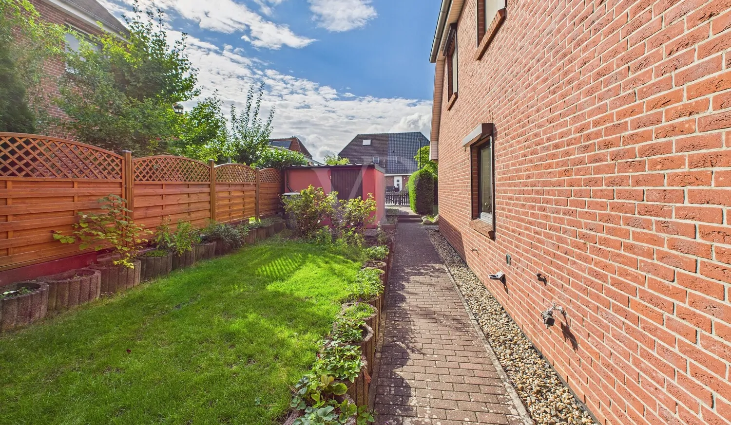 Blick auf die Garage und auf die gepflasterten Gehwege