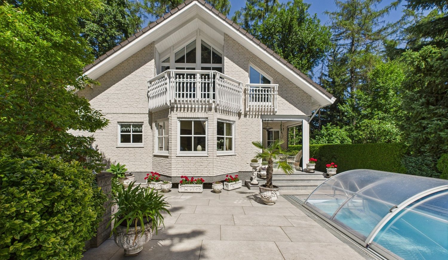 Blick auf das Haus sowie auf den Pool und Terrassenbereich