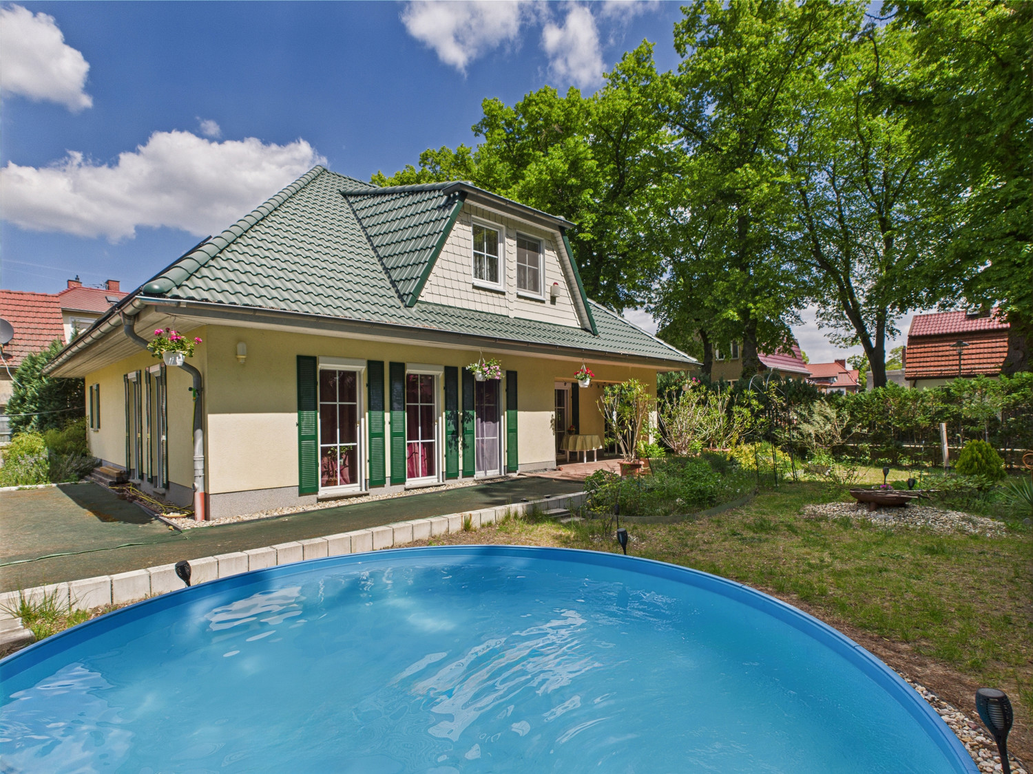Hausansicht von hinten mit Pool und Blick in den Garten