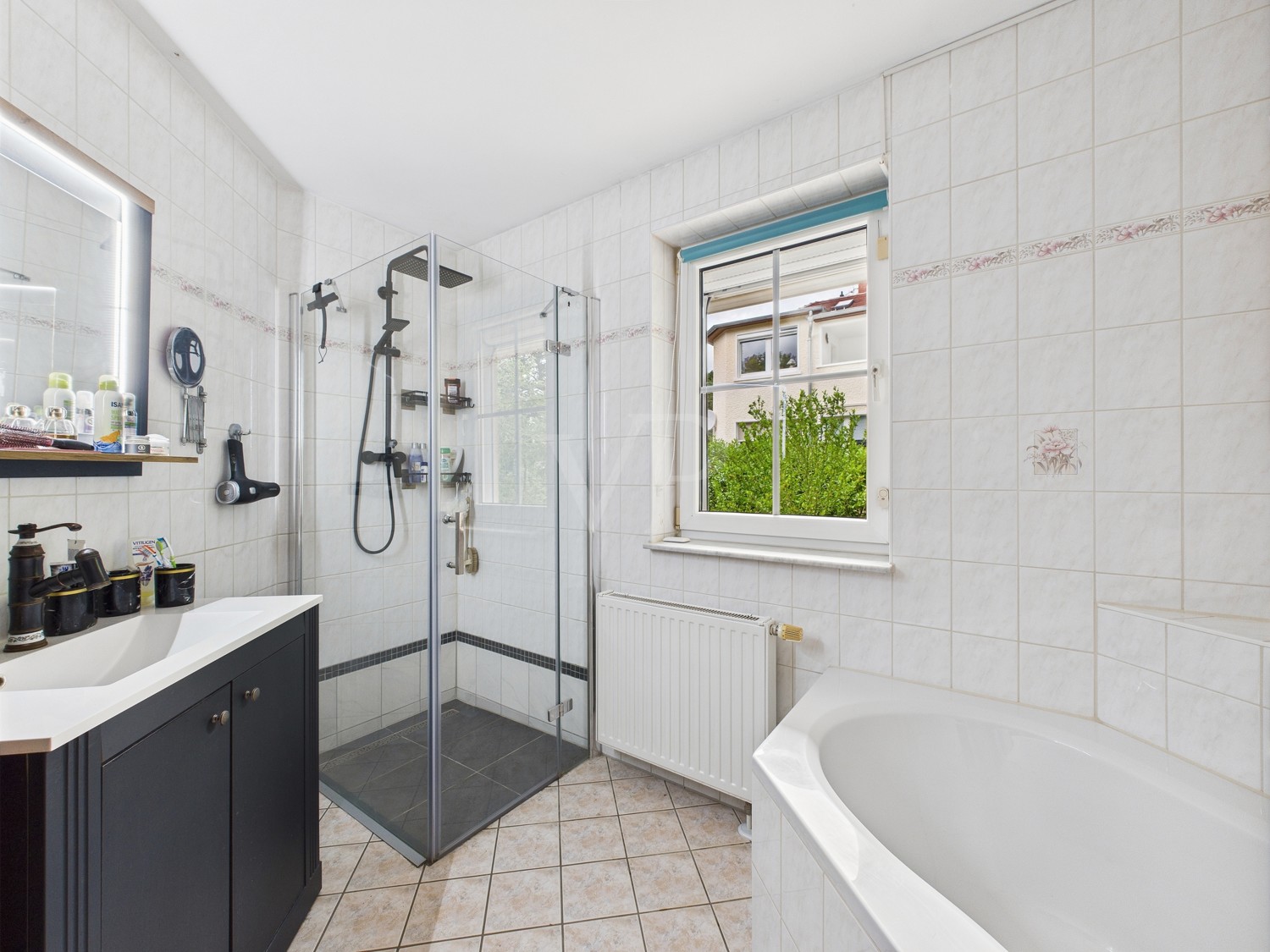 Badezimmer mit ebenerdiger Dusche und Badewanne