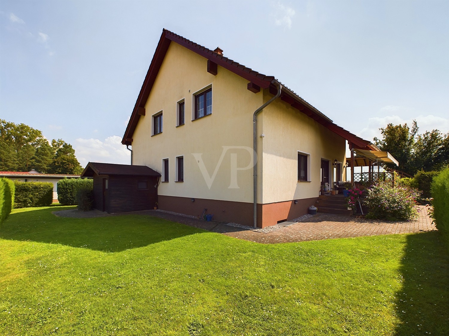 Hausansicht von hinten mit Blick in den Garten und auf die Terrasse