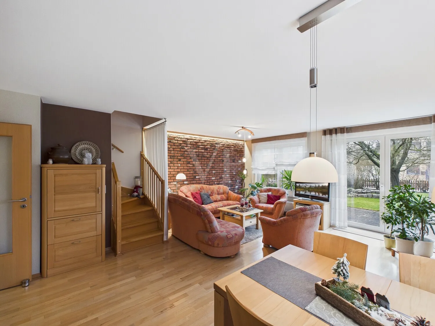 Wohn- und Essbereich mit Zugang zur Terrasse und dem Garten