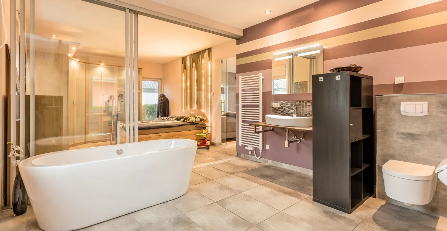 Masterbad mit verstellbarer Glasfront, freistehender Badewanne, ebenerdiger Dusche, WC, Waschtisch und Urinal