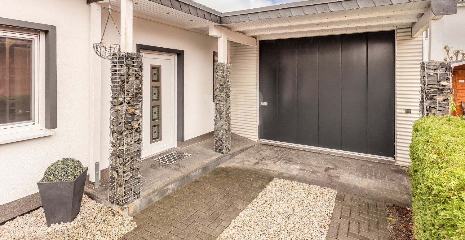 Blick auf den überdachten Eingangsbereich und die Garage
