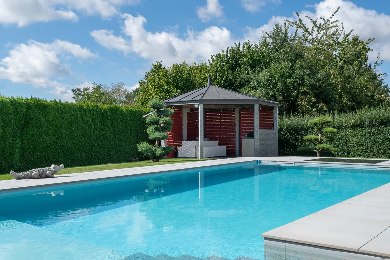 Natursteinelemente säumen den Solar beheizten Pool