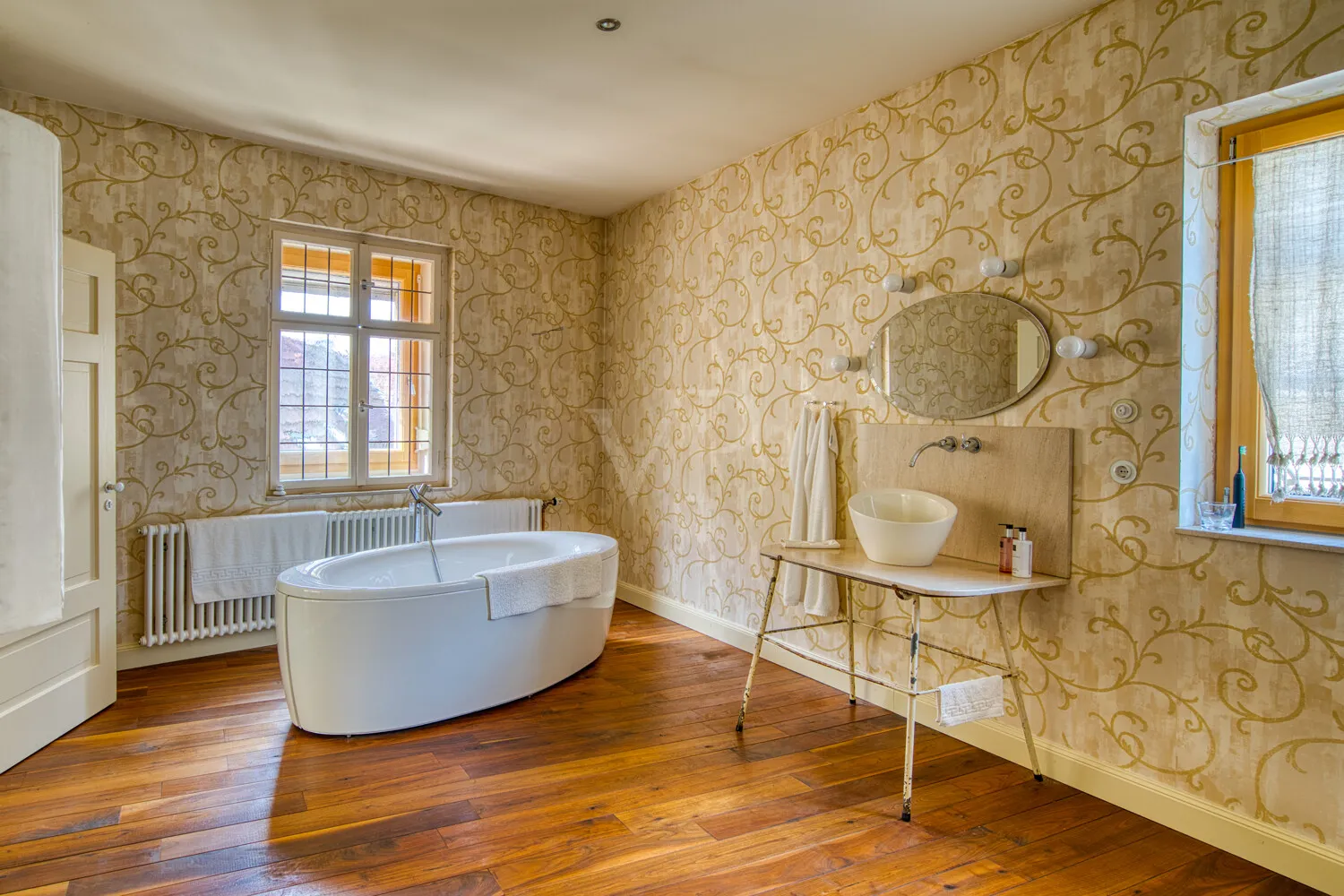 Wohnbad im Altbaustil: freistehende Wanne, Dielenboden und historische Details